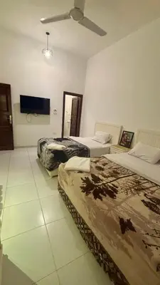 a bedroom with two beds and a flat screen tv at Moon House of Luxor in Luxor