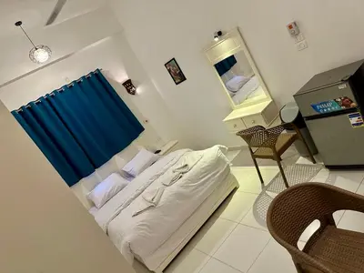 a bedroom with a bed with a blue curtain and a mirror at Moon House of Luxor in Luxor