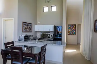 a kitchen with a counter with chairs and a table at tawila t1-17 -5 bed room big villa in Hurghada