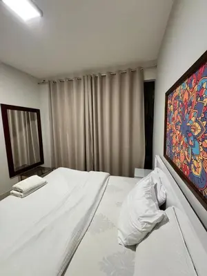 a bedroom with a white bed with a painting on the wall at tawila t1-17 -5 bed room big villa in Hurghada