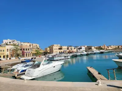 a group of boats docked in a marina with buildings at Mangroovy Comfy 2 Bedroom in Hurghada