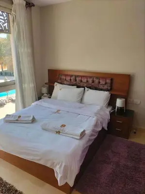 a bedroom with a large bed with two towels on it at Mangroovy Comfy 2 Bedroom in Hurghada