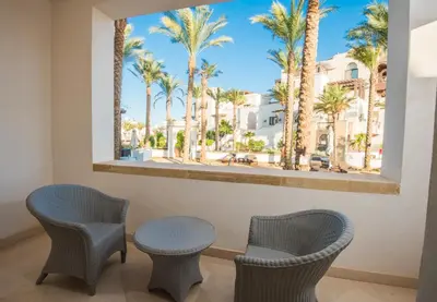 a room with two chairs and a window with palm trees at A S 2108 / 3 bedroom in Hurghada
