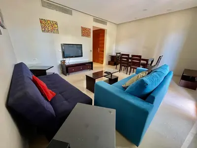a living room with two blue couches and a television at A S 2108 / 3 bedroom in Hurghada