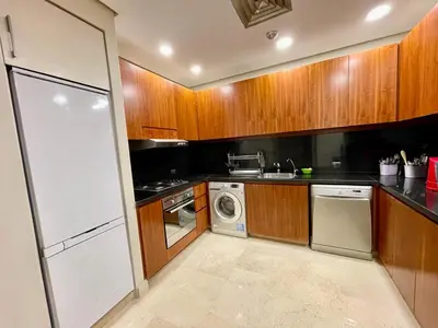 a kitchen with wooden cabinets and a washer and dryer at A S 2108 / 3 bedroom in Hurghada