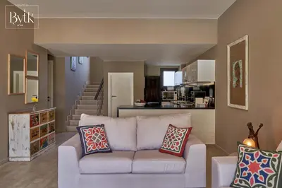 a living room with a white couch and a kitchen at BYTK - La Galería in Hurghada