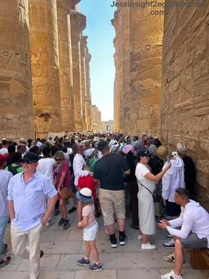 a large crowd of people standing in an ancient building at Cleopatra Nile Cruise in Luxor