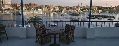 a balcony with a table and chairs and a harbor at La Terrace in Aswan