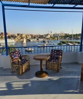 a patio with a table and chairs and a view of a river at La Terrace in Aswan