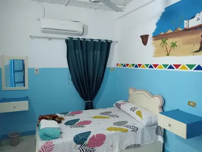 a bedroom with a bed and a blue wall at Sabaha Kato in Aswan