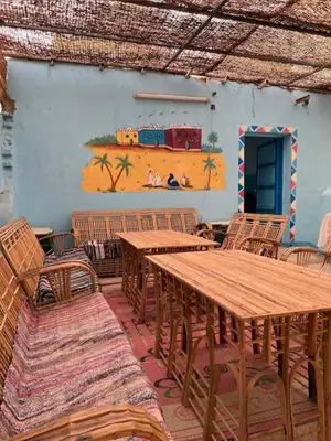 a room with tables and chairs and a painting of a train at Sabaha Kato in Aswan