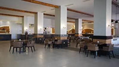 a restaurant with tables and chairs in a room at Amarina Jannah Resort & Aqua Park Marsa Alam in Coraya Bay