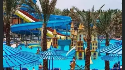 a water park with a water slide and palm trees at Family Suite in view aqua mirage bay in Hurghada