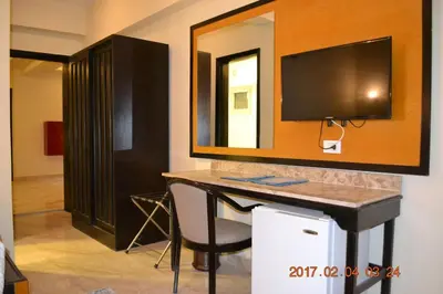 a room with a desk with a tv and a mirror at Jawhara Inn Hotel - فندق الجوهرة سفاجا in Hurghada