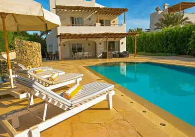 a villa with a swimming pool and a house at Stylish 4BR Villa V15 with a Private Heated Pool at White Villas in Hurghada