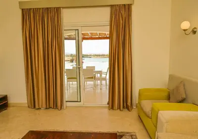 a living room with a yellow couch and a table at Stylish 4BR Villa V15 with a Private Heated Pool at White Villas in Hurghada