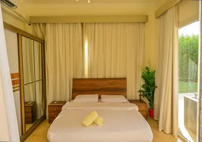 a bedroom with a large bed with two yellow pillows at Stylish 4BR Villa V15 with a Private Heated Pool at White Villas in Hurghada
