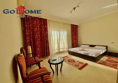 a bedroom with a bed and a chair and a table at Stylish 4BR Villa V15 with a Private Heated Pool at White Villas in Hurghada