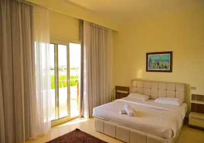 a bedroom with a large bed and a large window at Stylish 4BR Villa V15 with a Private Heated Pool at White Villas in Hurghada