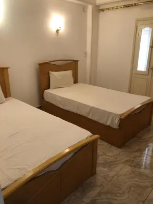 two beds in a small room with a window at Sea view apartment in Hurghada