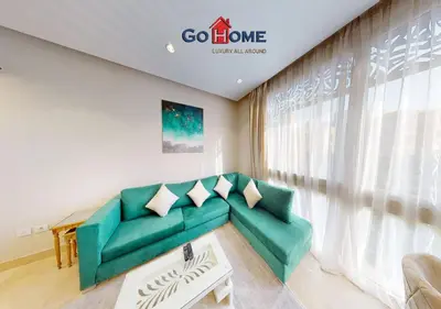 a living room with a green couch in front of a window at Beautiful 2B. Rooms M7-4B Mangaroveey in Hurghada