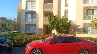 a red car parked in front of a building at Beautiful 2B. Rooms M7-4B Mangaroveey in Hurghada