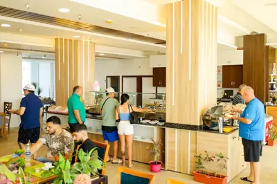 a group of people standing in a kitchen at Shellghada Blue Beach in Hurghada