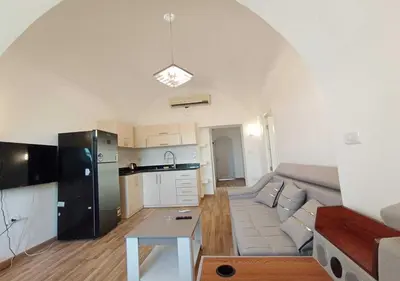 a living room with a couch and a kitchen at Two Bedrooms at Kafr El-Gouna N14 in Hurghada