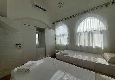 a white bedroom with two beds and a window at Two Bedrooms at Kafr El-Gouna N14 in Hurghada