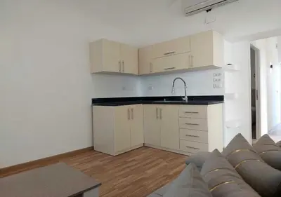 a kitchen with white cabinets and a couch in a room at Two Bedrooms at Kafr El-Gouna N14 in Hurghada