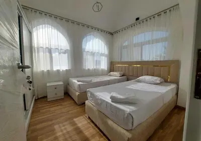 two beds in a bedroom with two windows at Two Bedrooms at Kafr El-Gouna N14 in Hurghada