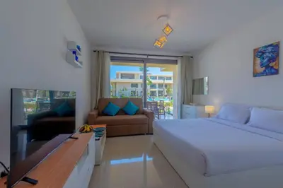 a bedroom with a bed and a couch and a table at Ground Floor Studio - G Cribs -Elgouna in Hurghada