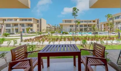a wooden table and two chairs on a patio at Ground Floor Studio - G Cribs -Elgouna in Hurghada