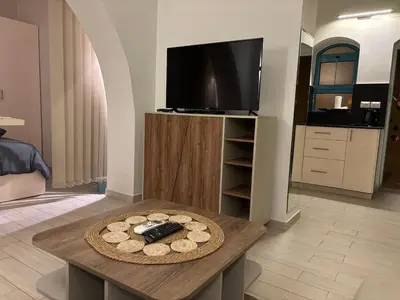 a living room with a table and a tv at Stay in the center of Elgouna in Hurghada