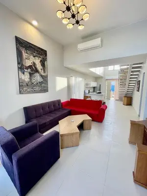 a living room with a red couch and a table at tawila T 31 in Hurghada