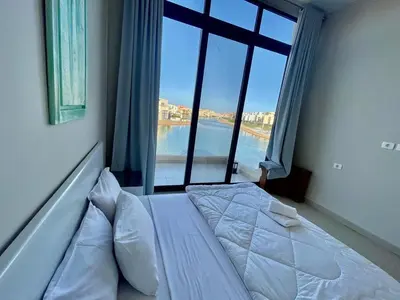 a bed in a room with a large window at tawila T 31 in Hurghada
