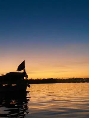 a boat on the water at sunset at Asilah kato nubian guest house in Aswan