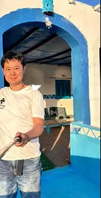a man holding a baseball bat in a batting cage at Asilah kato nubian guest house in Aswan