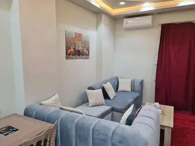 a living room with two blue couches at Hurghada Appartment front of dream beach in Hurghada
