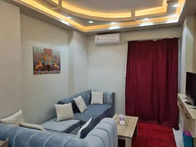 a living room with blue couches and a red curtain at Hurghada Appartment front of dream beach in Hurghada