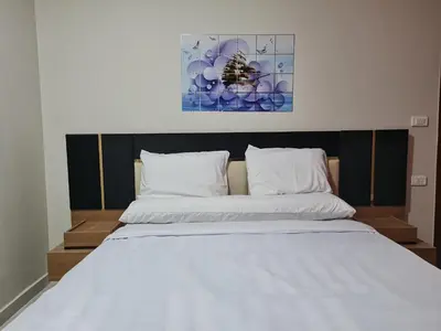 a bedroom with a large bed with white sheets at Hurghada Appartment front of dream beach in Hurghada