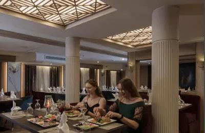 two women sitting at a table in a restaurant at ToBadaa - Nile cruise all inclusive from Aswan or Luxor 4 Days & 7 days in Aswan
