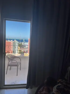 a child laying on a bed looking out a window at Hurghada's Marina view in Hurghada
