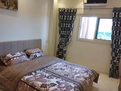 a bedroom with a bed and a window with curtains at Hurghada's Marina view in Hurghada