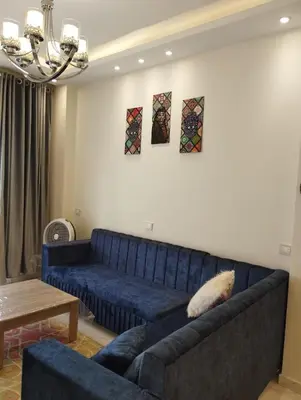 a blue couch in a living room with a table at Hurghada's Marina view in Hurghada