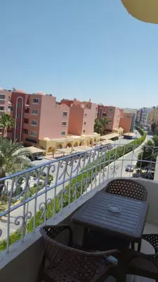 a table and chairs on a balcony with a view of a city at Hurghada's Marina view in Hurghada