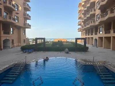 a couple of people in a swimming pool in a building at My Sky Sea View 1 Bedroom Apartment in Hurghada