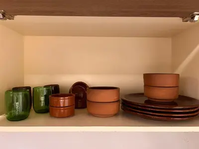 a shelf filled with different colored cups and plates at My Sky Sea View 1 Bedroom Apartment in Hurghada