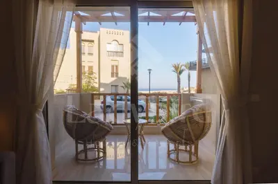 a balcony with a view of a building from a window at Ladybird - Azzurra Beauty in Hurghada