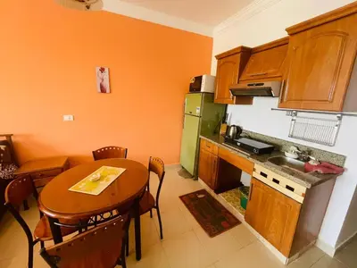 a kitchen with a wooden table and a kitchen with a table and chairs at Navy Chalet 108 in Hurghada